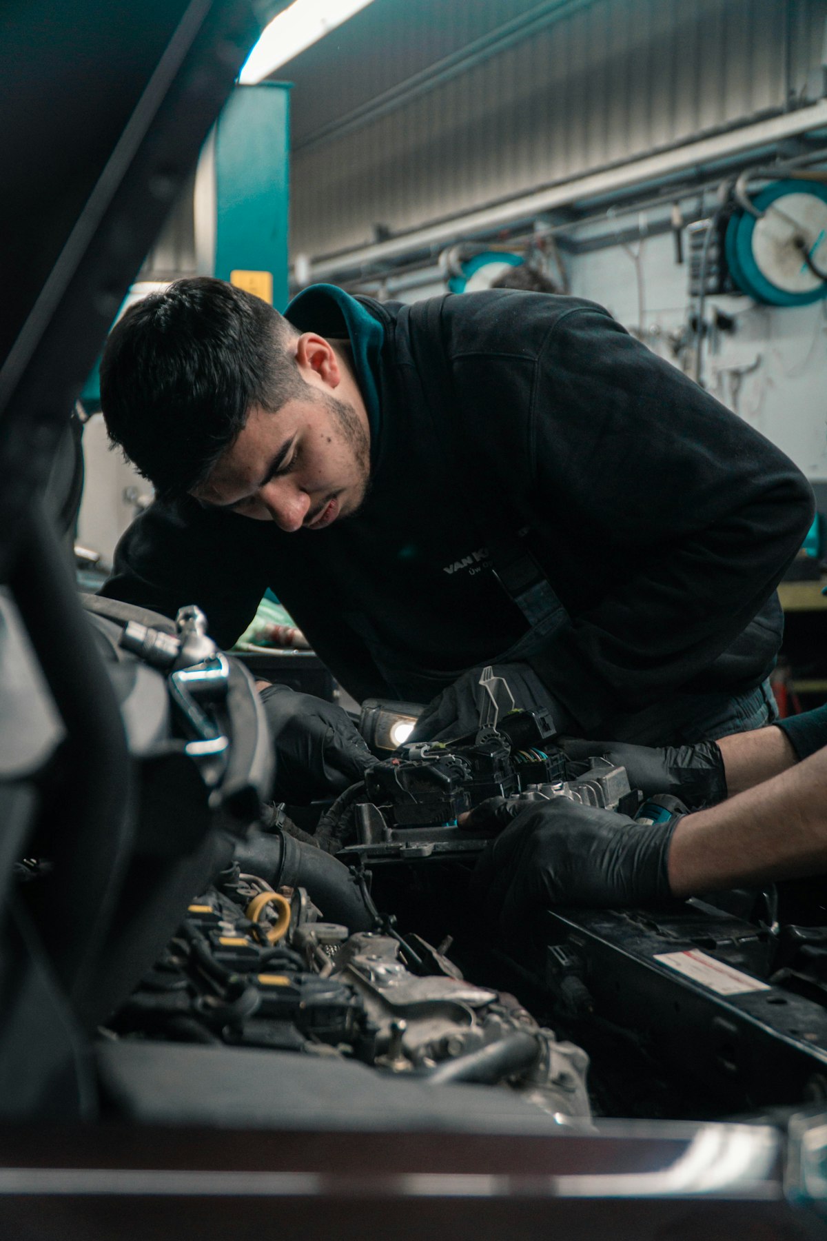 Technician spray-painting a car body panel